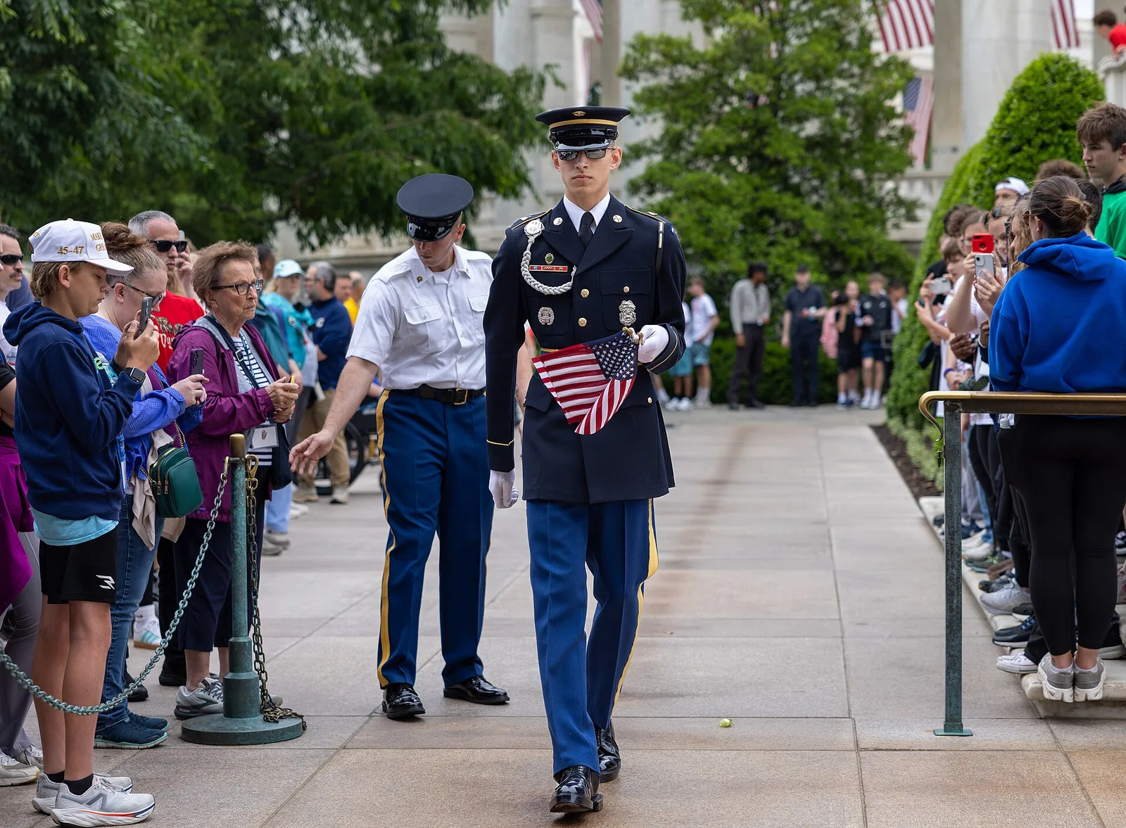 A Tomb Guard of the 3d U.S. Infantry Regiment sets flags at the Tomb of the Unknown Soldier during Flags In at Arlington National Cemetery.