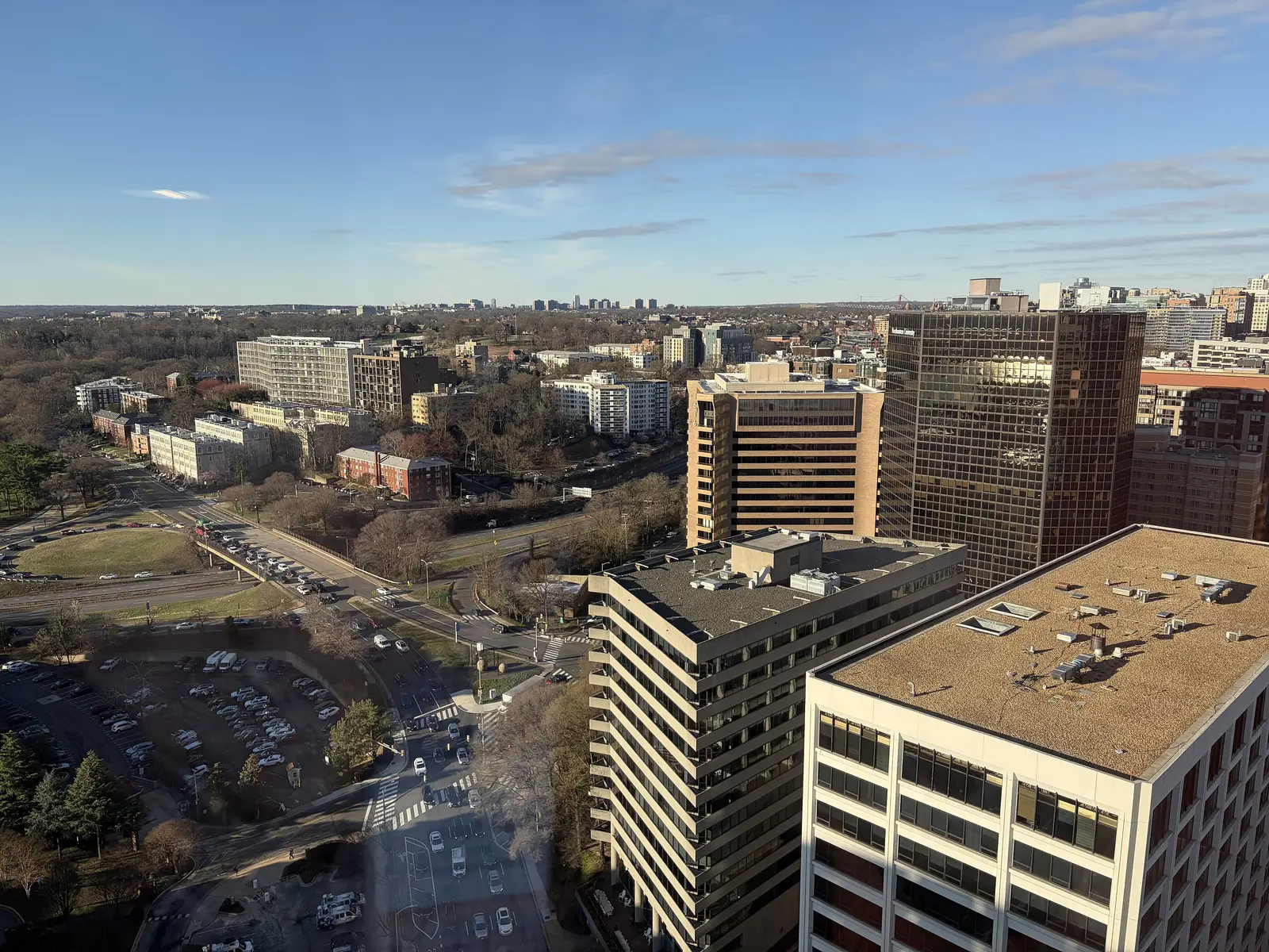 Office and apartment buildings in Rosslyn seen from high above, with the tree cover of North Arlington beyond.