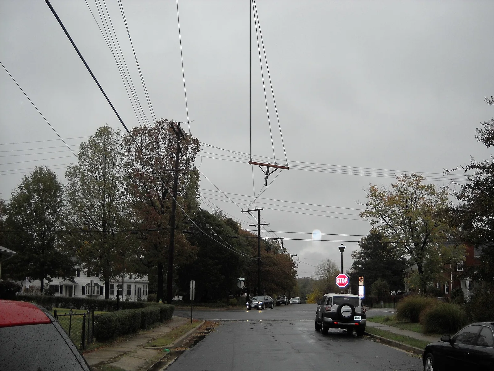 A broken crossarm hangs from power lines over a residential street in Arlington after Hurricane Sandy.