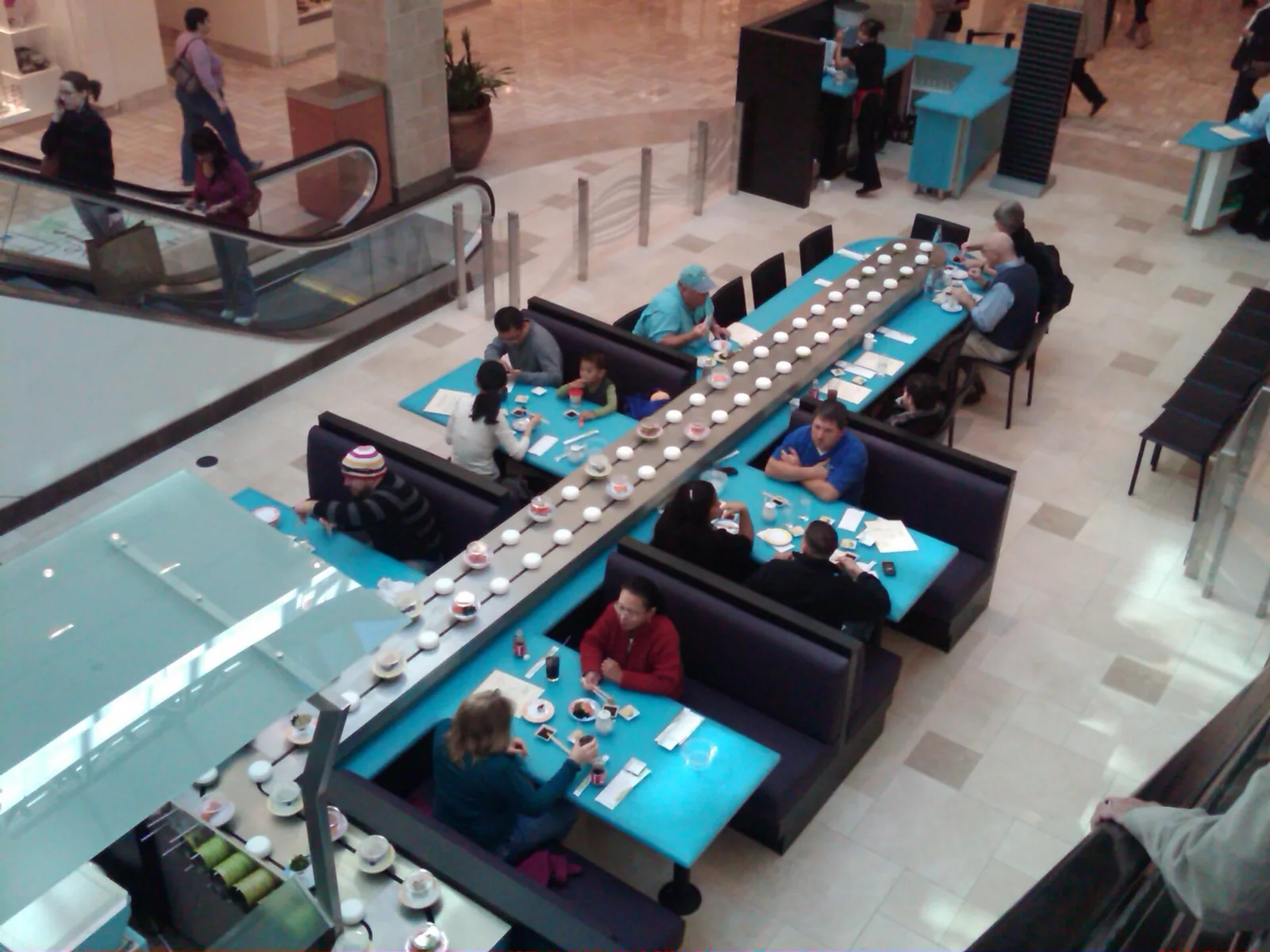 Plates of sushi on a long conveyor belt.