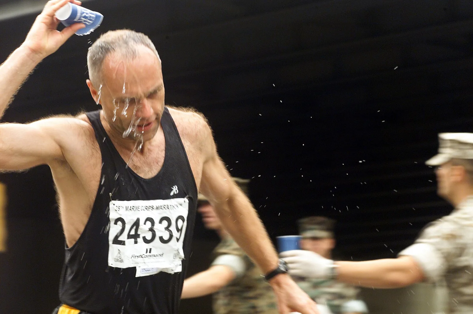 Runners pour water over their heads at mile 23 of the Marine Corps Marathon in Crystal City, Arlington.