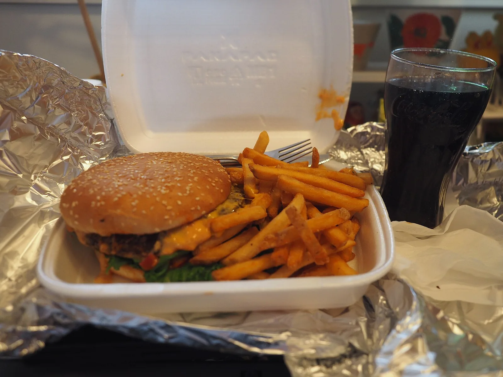 A cheeseburger and fries in a takeout box.