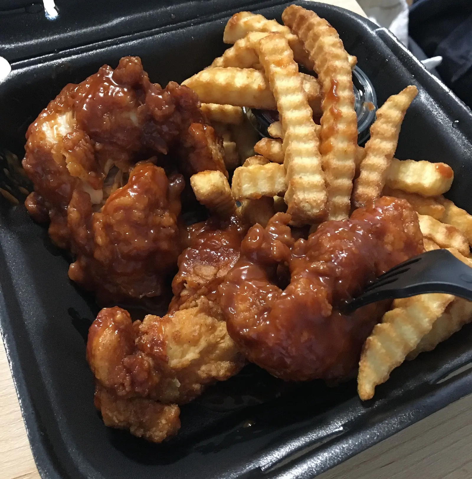 A plate of boneless chicken wings with fries.